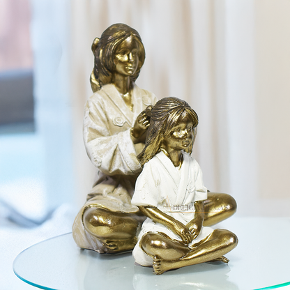 Escultura decorativa mãe e filha em resina dourada, peça elegante e simbólica para decoração de sala, quarto ou estante.