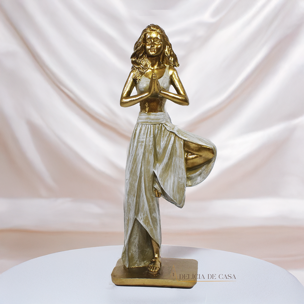 Estatueta decorativa de resina representando uma mulher em posição de yoga, equilibrada sobre uma perna, com as mãos unidas em prece, simbolizando paz e harmonia