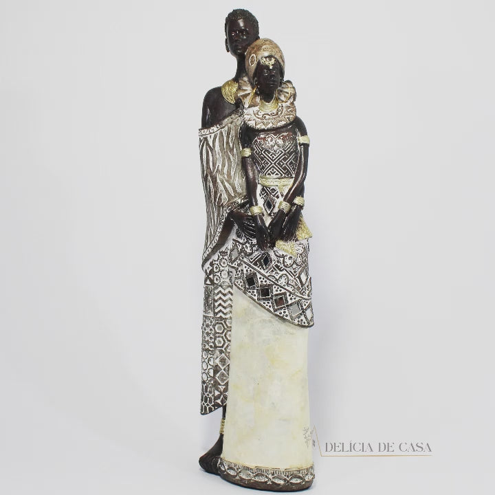 Escultura de casal africano em resina, com trajes típicos detalhados, decoração étnica moderna.