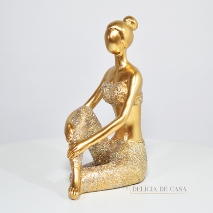 Escultura de mulher em posição de yoga com acabamento dourado e glitter. Uma peça decorativa que une elegância e serenidade, perfeita para decorar ou presentear.